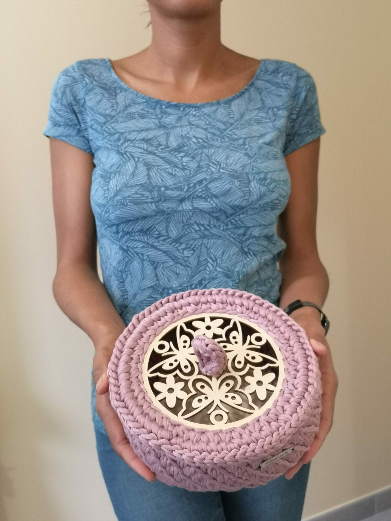 Panier fil rose avec couvercle sculpté porté par une femme