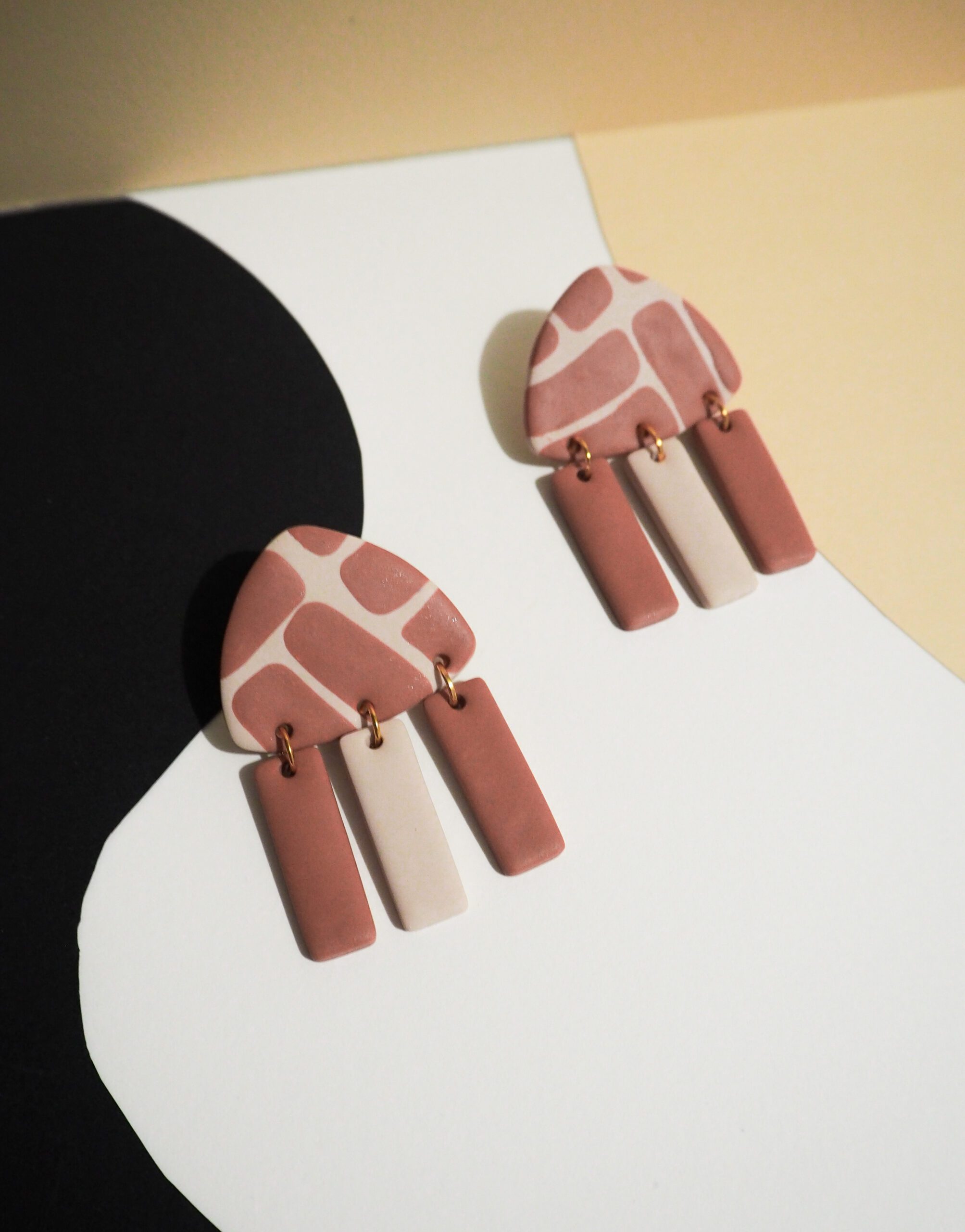Boucles d'oreilles forme triangle beige avec motif rayé terracotta et pendants beige et terracotta