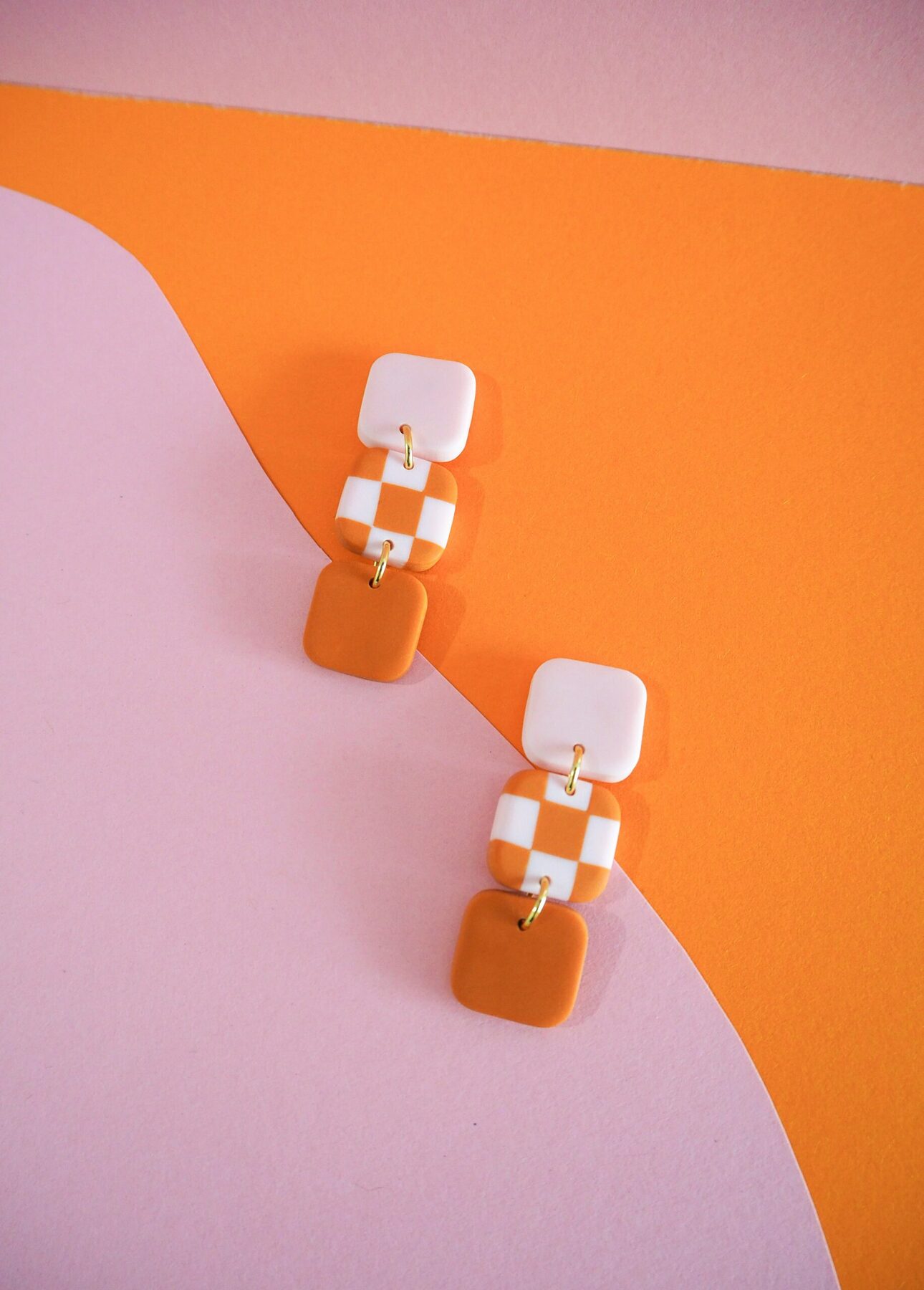 Boucles d'oreilles avec carré rose pale, carré motif damier rose pale et orange et carré orange
