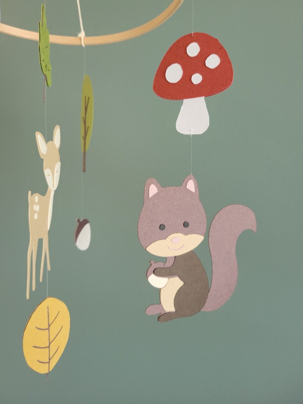 Mobile chambre bébé mixte en papier recyclé, motifs forêt avec faon, champignons et feuilles.