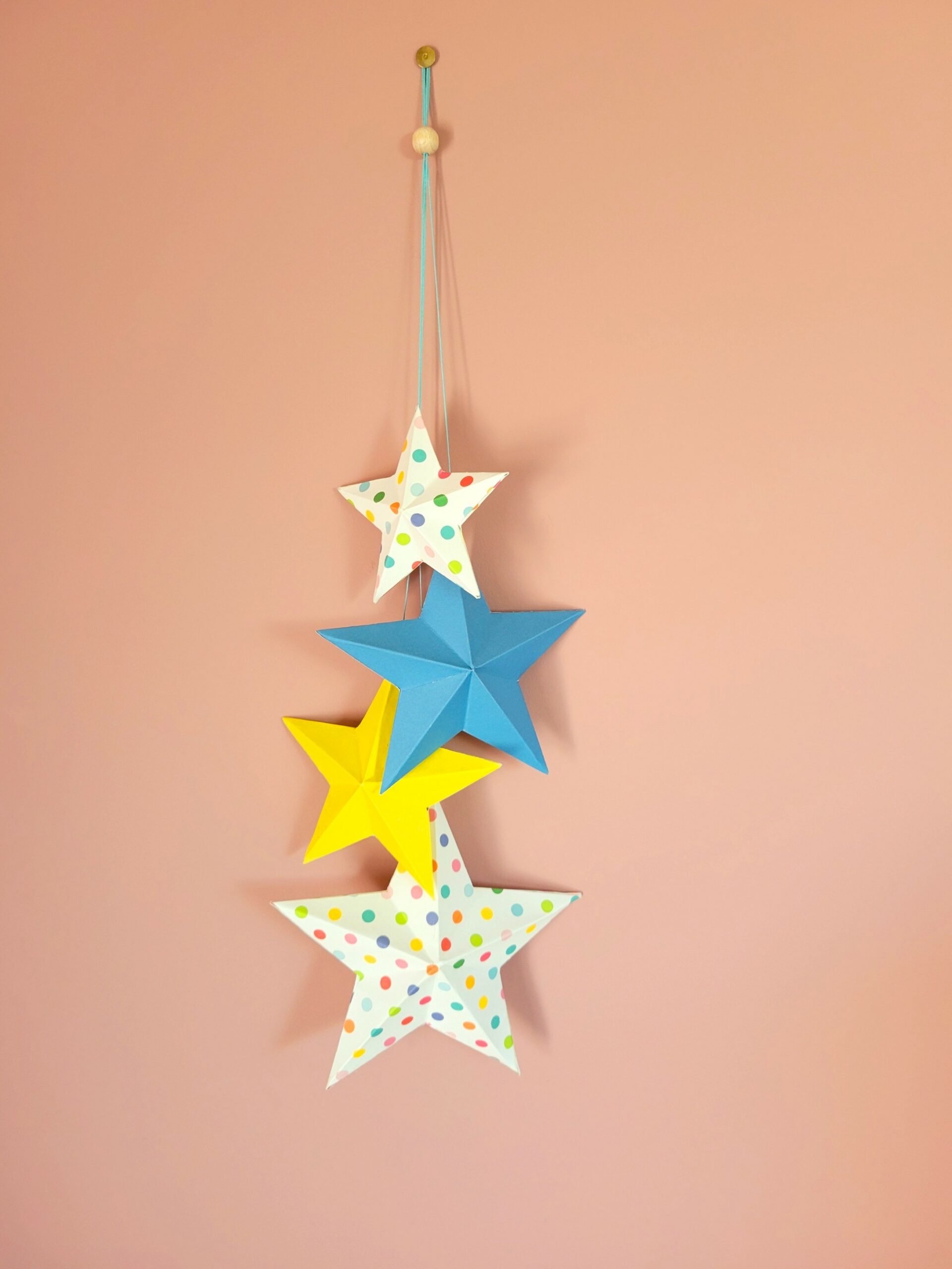 Découvrez l'art de la décoration origami avec cette suspension étoiles colorées où chaque pli révèle une technique parfaitement maîtrisée. Les motifs pois multicolores dansent avec élégance dans cette déco murale étoiles papier unique.