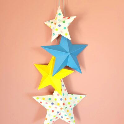 Admirez le contraste saisissant entre les étoiles suspendues colorées et le mur rose poudré. Cette décoration étoile suspendue de 50cm crée un point focal captivant qui égaye instantanément la pièce.
