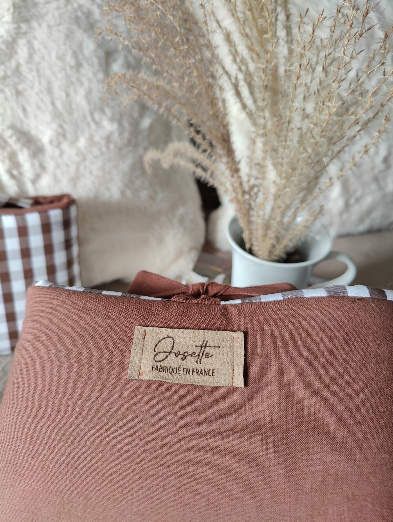 Détail du tissu marron uni et de l’étiquette Josette cousue sur la pochette.