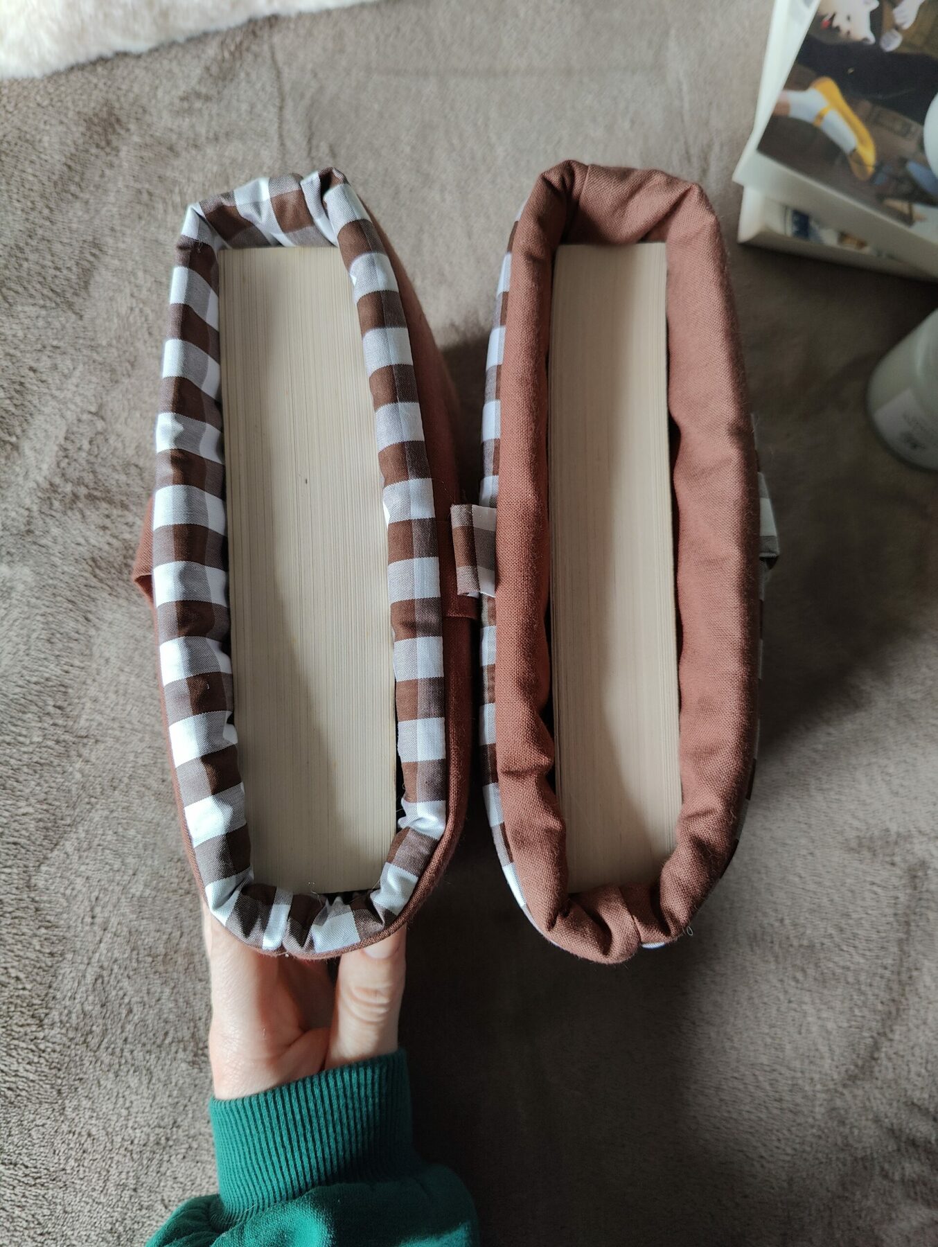 Vue du dessus des deux pochettes ouvertes montrant les tissus intérieurs et un livre inséré.
