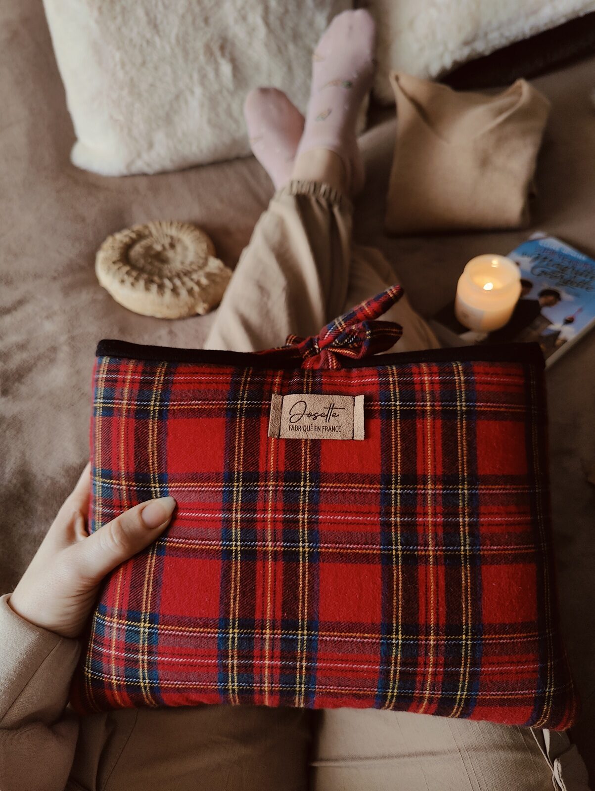 Pochette tartan tenue sur les genoux lors d’un moment de lecture cosy.