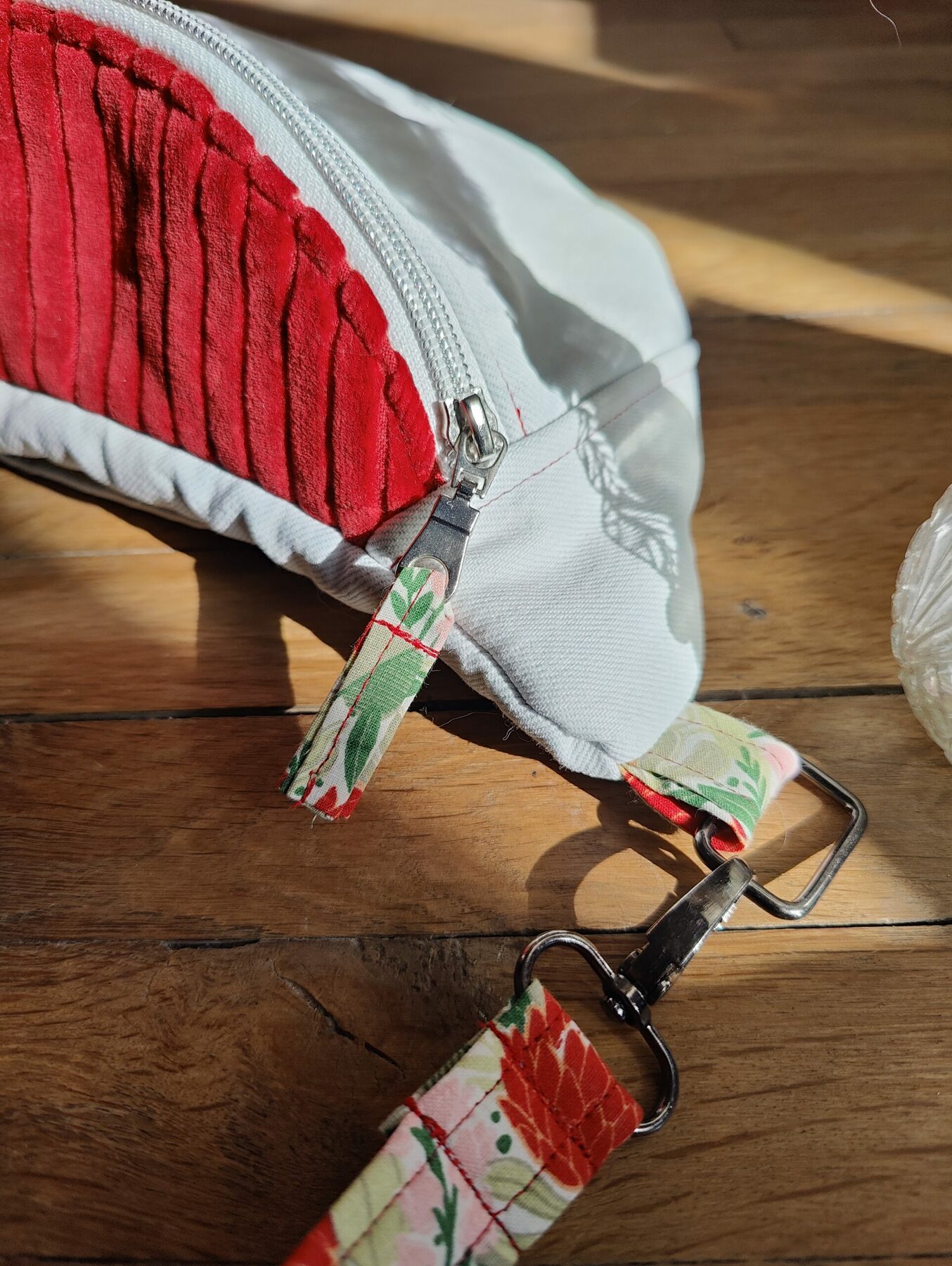 Sac banane upcyclé jean blanc. Dessus velours rouge. Détail zip