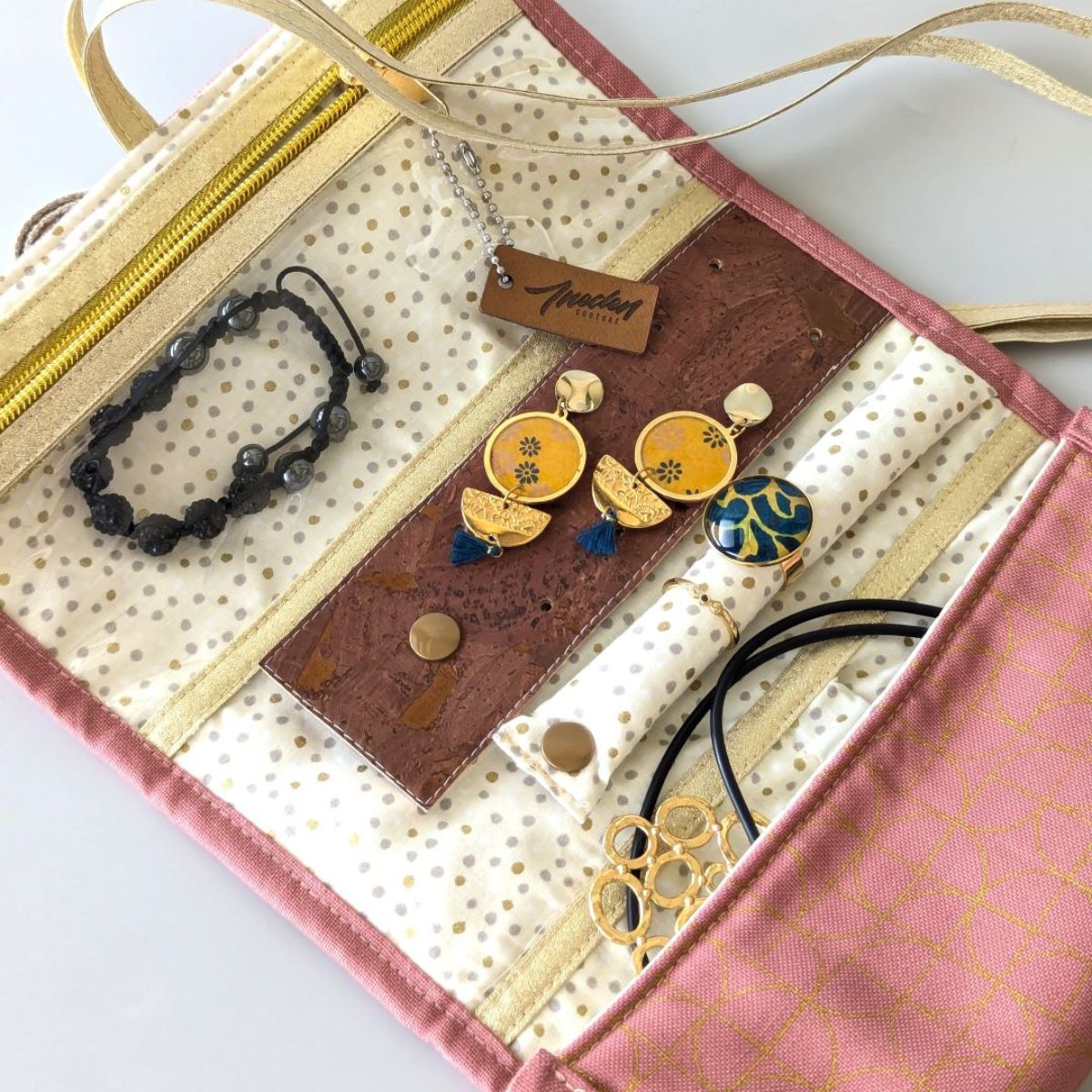 Pochette à bijoux de voyage rose et beige pois dorés garni de ses bijoux