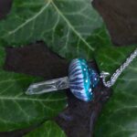 Pendentif en forme de champignon avec pied en cristal de roche naturel.
Pendentif 3x5 cm, chaîne 45 cm.
Quartz naturel, pâte polymère, résine d'époxy.
Bleu vert, bleu lagon, bleu canard, transparent.
Soigneusement emballé dans une boîte cadeau prête à offrir.
Fluorescent réactif à la lumière UV néon, phosphorescent lumineux dans le noir.
Féerique, forêt, cottagecore, fairycore, boho, psychédélique, witchy, kawaii, mignon, fantastique, champêtre.